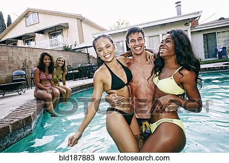 Stock Image - Friends playing in swimming pool. Fotosearch