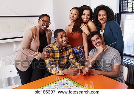Friends smiling at party View Large Photo Image Stock Photo - Friends smiling at party. Fotosearch