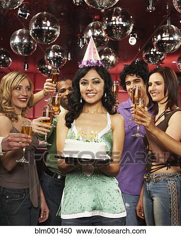Stock Image - Friends toast woman holding birthday cake. Fotosearch