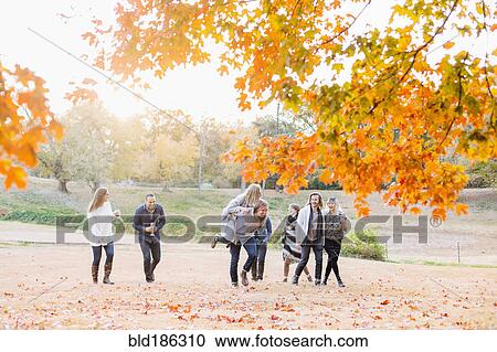 Stock Image - Friends walking in rural field. Fotosearch