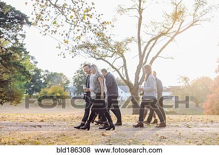 Stock Photo - Friends walking in rural field. Fotosearch