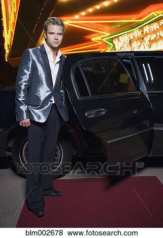 Stock Photo - German man standing by limousine outside nightclub. Fotosearch