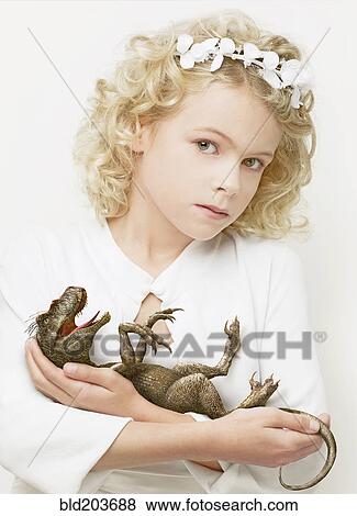 Stock Photo - Girl cradling baby dinosaur. Fotosearch