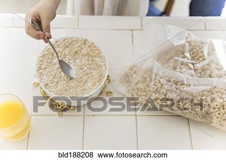 Stock Photo - Girl eating bowl of cereal. Fotosearch