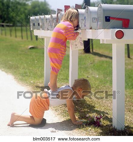 Stock Photo - Girl standing on brother's back and peering into mailbox. Fotosearch