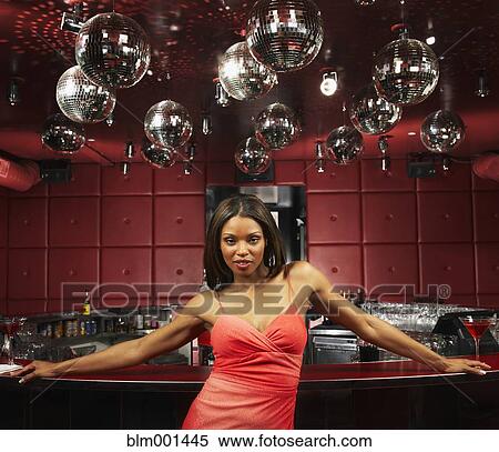 Stock Photography - Glamorous African woman leaning on bar in nightclub. Fotosearch
