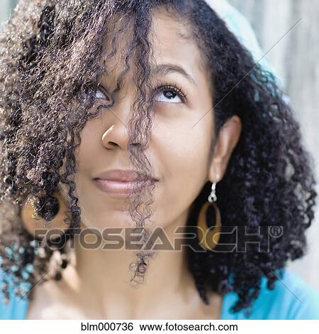 Stock Photograph - Glamorous mixed race woman looking up. Fotosearch