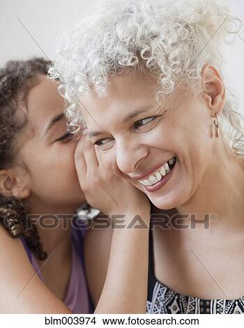 Picture - Granddaughter whispering into grandmotherÆs ear. Fotosearch