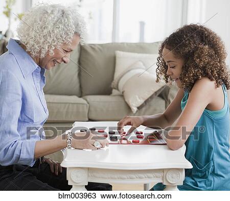 Grandmother and granddaughter playing checkers View Large Photo Image Stock Image - Grandmother and granddaughter playing checkers. Fotosearch
