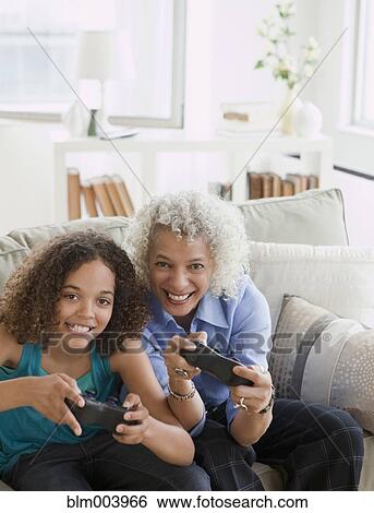 Grandmother and granddaughter playing video game View Large Photo Image Stock Photograph - Grandmother and granddaughter playing video game. Fotosearch