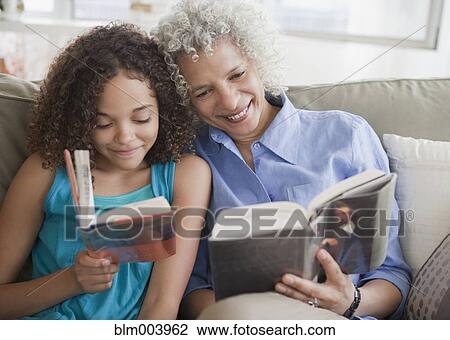 Grandmother and granddaughter reading on sofa View Large Photo Image Stock Image - Grandmother and granddaughter reading on sofa. Fotosearch