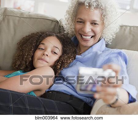 Picture - Grandmother and granddaughter taking self-portrait. Fotosearch