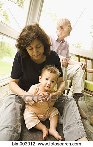 Stock Image - Grandmother playing with mixed race grandson. Fotosearch