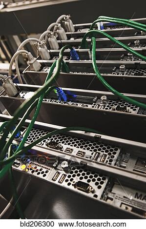 Stock Image - Green Cables Connected to the Back of a Server. Fotosearch