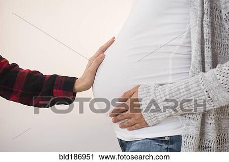 Hand feeling belly of pregnant woman View Large Photo Image Stock Image - Hand feeling belly of pregnant woman. Fotosearch