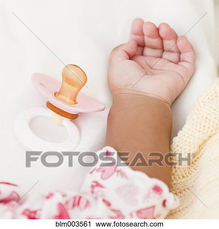 Hand of African baby and pacifier View Large Photo Image Stock Image - Hand of African baby and pacifier. Fotosearch