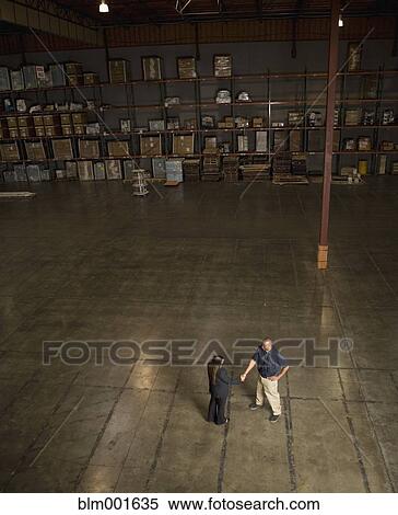 High angle view of businesspeople shaking hands in warehouse View Large Photo Image Stock Photography - High angle view of businesspeople shaking hands in warehouse. Fotosearch
