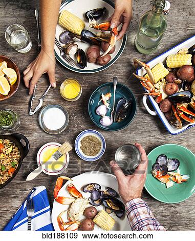 High angle view of hands at seafood dinner View Large Photo Image Stock Photo - High angle view of hands at seafood dinner. Fotosearch