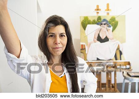 Stock Photography - Hispanic artist smiling in studio. Fotosearch