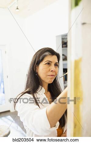 Picture - Hispanic artist working in studio. Fotosearch