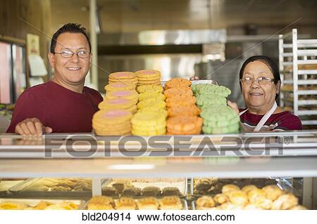 Picture - Hispanic bakers smiling in kitchen. Fotosearch