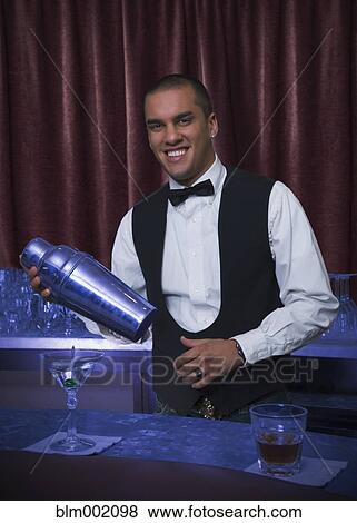 Stock Photo - Hispanic bartender making cocktail. Fotosearch