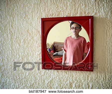 Stock Photo - Hispanic boy admiring himself in mirror. Fotosearch