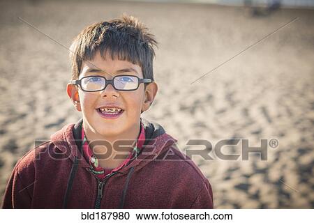 Stock Image - Hispanic boy smiling on beach. Fotosearch