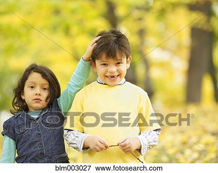 Stock Photo - Hispanic brother and sister outdoors in autumn. Fotosearch