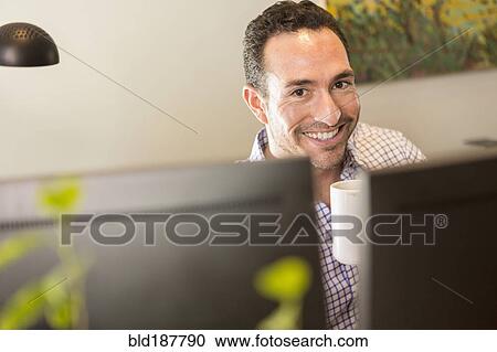 Hispanic businessman drinking coffee in office View Large Photo Image Stock Image - Hispanic businessman drinking coffee in office. Fotosearch