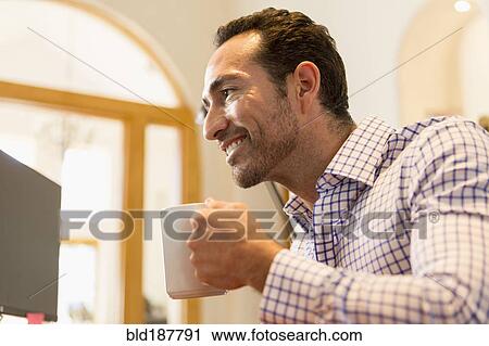 Hispanic businessman drinking coffee in office View Large Photo Image Stock Image - Hispanic businessman drinking coffee in office. Fotosearch