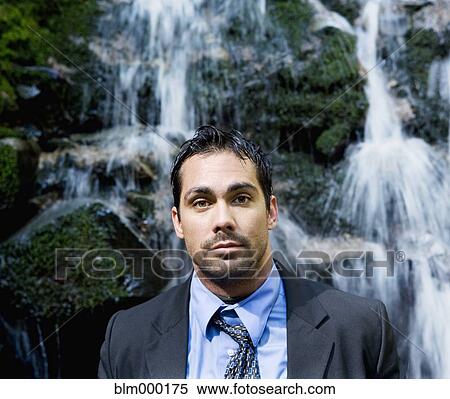 Stock Photography - Hispanic businessman in front of waterfall. Fotosearch