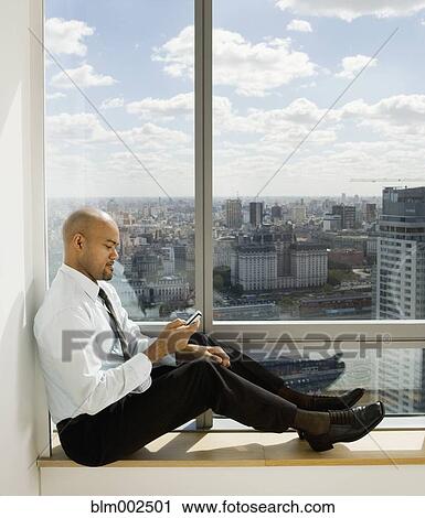 Hispanic businessman looking at cell phone View Large Photo Image Stock Image - Hispanic businessman looking at cell phone. Fotosearch