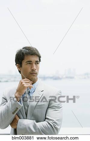 Stock Image - Hispanic businessman looking pensive. Fotosearch