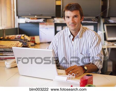 Hispanic businessman sitting at desk View Large Photo Image Stock Image - Hispanic businessman sitting at desk. Fotosearch