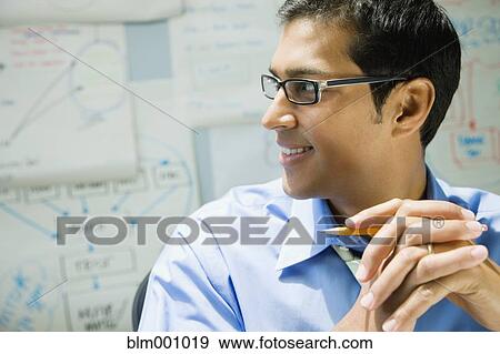 Hispanic businessman sitting in front of flip chart sheets View Large Photo Image Stock Photo - Hispanic businessman sitting in front of flip chart sheets. Fotosearch