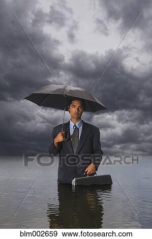 Stock Photo - Hispanic businessman standing in water. Fotosearch