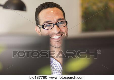 Stock Image - Hispanic businessman using computer in office. Fotosearch