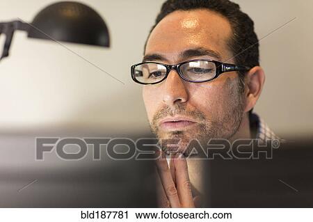 Stock Image - Hispanic businessman using computer in office. Fotosearch