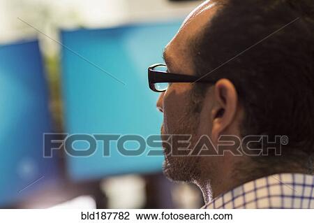 Stock Image - Hispanic businessman using computer in office. Fotosearch