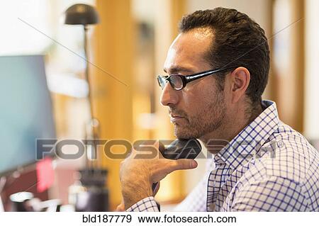 Hispanic businessman using computer in office View Large Photo Image Stock Photo - Hispanic businessman using computer in office. Fotosearch