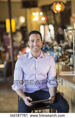 Hispanic businessman using digital tablet in coffee shop View Large Photo Image Stock Image - Hispanic businessman using digital tablet in coffee shop. Fotosearch