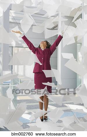 Stock Image - Hispanic businesswoman throwing papers in air. Fotosearch