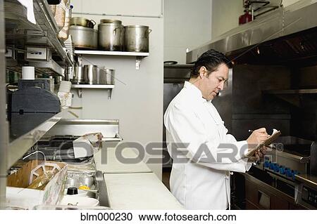 Stock Image - Hispanic chef preparing for dayÆs work. Fotosearch