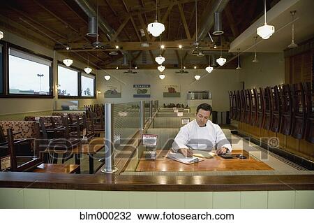 Stock Image - Hispanic chef preparing for dayÆs work. Fotosearch