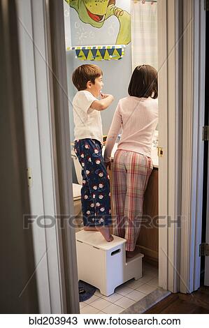 Stock Image - Hispanic children brushing their teeth. Fotosearch