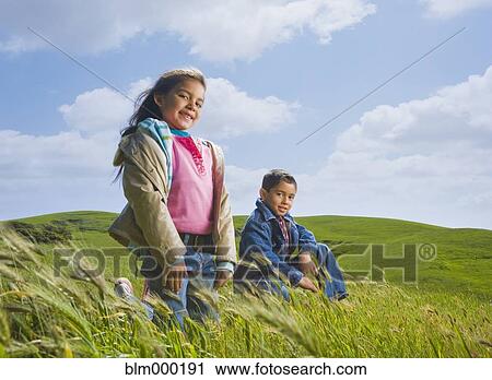 Hispanic children on grassy hillside View Large Photo Image Stock Image - Hispanic children on grassy hillside. Fotosearch