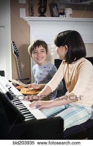 Hispanic children playing music in living room View Large Photo Image Stock Photography - Hispanic children playing music in living room. Fotosearch