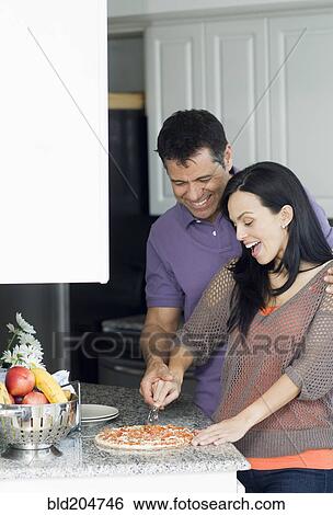 Hispanic couple cooking in kitchen View Large Photo Image Stock Photograph - Hispanic couple cooking in kitchen. Fotosearch