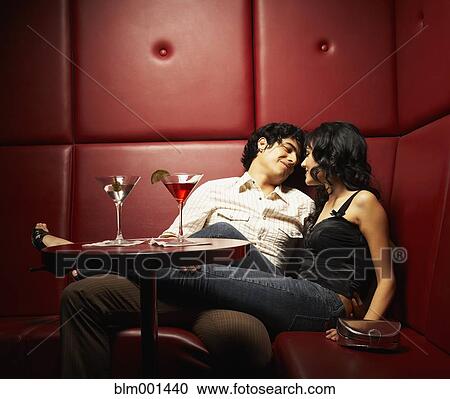 Stock Image - Hispanic couple cuddling in nightclub. Fotosearch